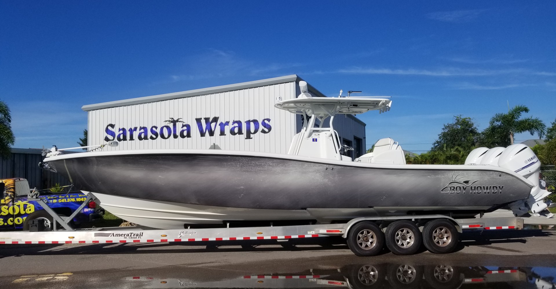 Boat wrap on a trailer in front of the Sarasota Wraps building